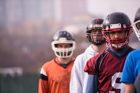 portrait of young american football team standing one behind the other on fieldの写真素材