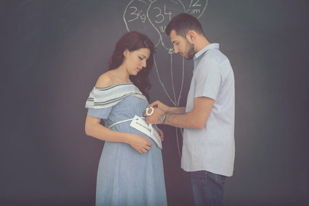 Conceptual photo of pregnant couple drawing their imaginations about the future life with children...