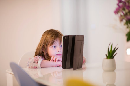 child playing with digital tablet at home