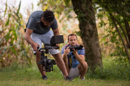Young videographer with gimball video slr recording while healthy woman doing yoga exercise in the...