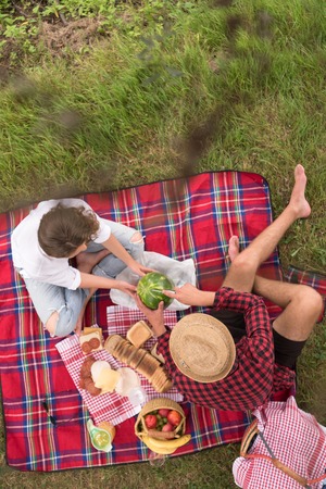 Couple in love enjoying picnic time drink and food in beautiful nature on the river bank top viewの写真素材