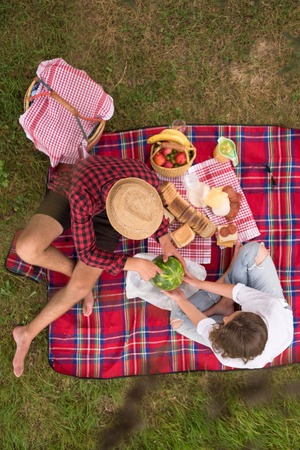 Couple in love enjoying picnic time drink and food in beautiful nature on the river bank top viewの写真素材