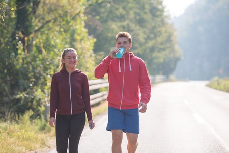 A young couple enjoying in a healthy lifestyle while jogging along a country road, exercise and fitness conceptの写真素材