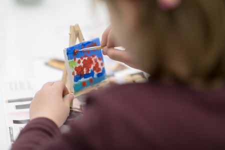happy little girl painting on canvas image at homeの写真素材