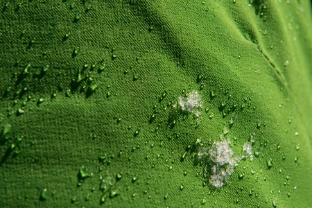 Snow and  water droplets on green waterproof fabric from skiing clothes in winterの素材 [FY310112771493]