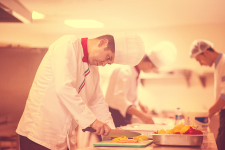 Chef cutting fresh and delicious vegetables for cooking or saladの写真素材