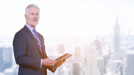 Portrait of senior businessman using tablet in front of big modern city