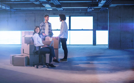 Young team of business people in group, architect and engineer on construction site checking documents and business workflow using laptop computer in new startup officeの写真素材
