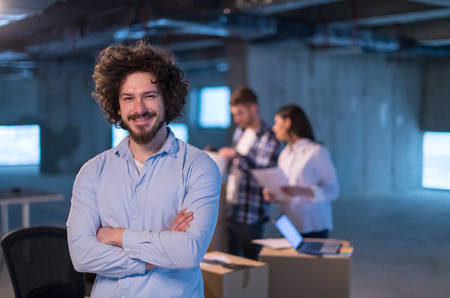 Young businessman on construction site checking documents and business workflow with colleagues in new startup officeの写真素材