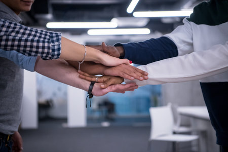 Multiethnic Group of young business people celebrating success at their working places in startup...