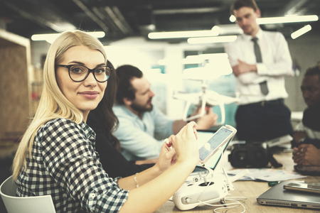 Young blonde business woman with her multiethnic startup business team discussing new business planの写真素材
