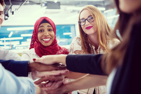 Young multiethnic Group of young business people celebrating success at their working places in...