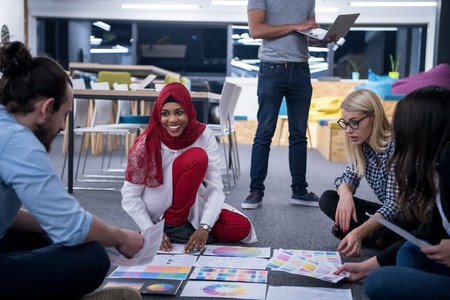 Young black muslim businesswoman having meeting with her multiethnic startup business team in modern office interiorの写真素材