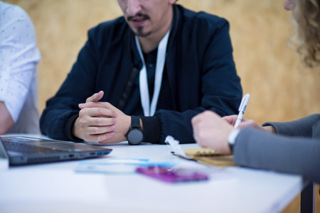 Business woman writing notes while discussing business plan on meeting at startup office interior,...