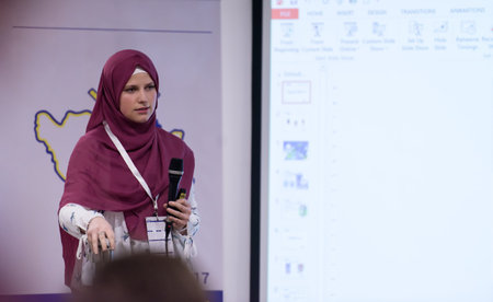 young muslim businesswoman with red scarf at business conference room giving public presentations....