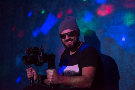 Young videographer with gimball video slr working in kids neon disco party