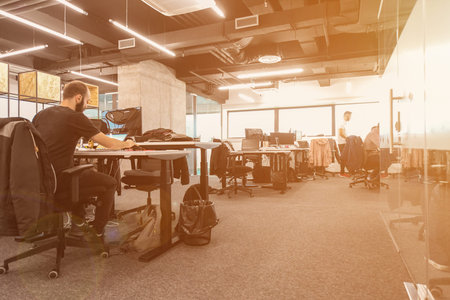software developers working everyday job writing programming code at modern sunny bright open plan...