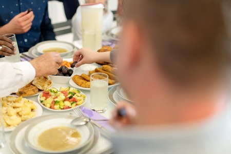 modern multiethnic muslim family enjoying eating iftar dinner together during a ramadan feast at homeの写真素材