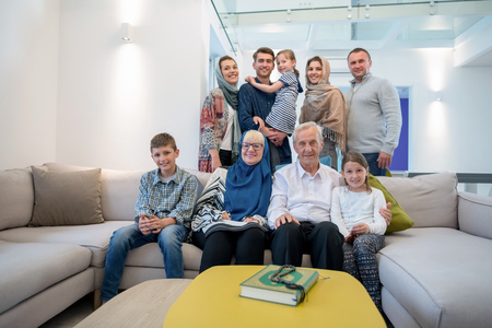 several generations portrait of happy modern muslim family before iftar dinner during ramadan feast at homeの写真素材