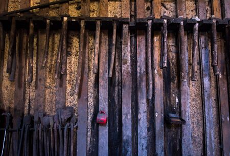 blacksmith tools hanging on a wooden wallの写真素材