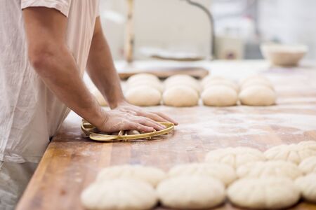 baker preparing the dough for products In a traditional bakeryの写真素材