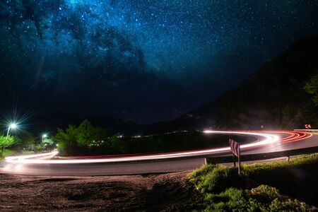 vegicle light trails in night on busy countryroad curve  long exposureの写真素材