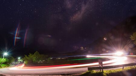vegicle light trails in night on busy countryroad curve  long exposureの写真素材