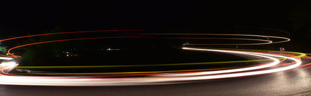 vegicle light trails in night on busy countryroad curve  long exposureの写真素材