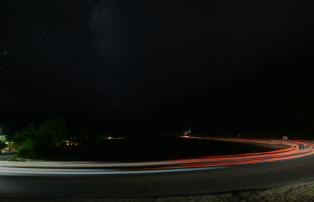 vegicle light trails in night on busy countryroad curve  long exposureの写真素材