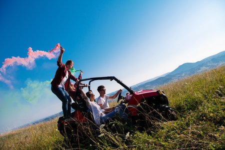 group of young happy excited people having fun enjoying beautiful sunny day holding colorful torches...