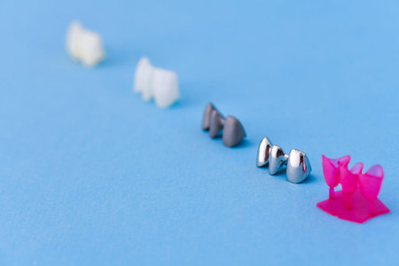 different types of dental tooth crowns isolated on blue backgroundの写真素材