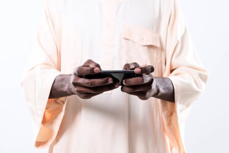 african man using smartphone and wearing traditioinal sudan clothes isolated on white backgroundの写真素材