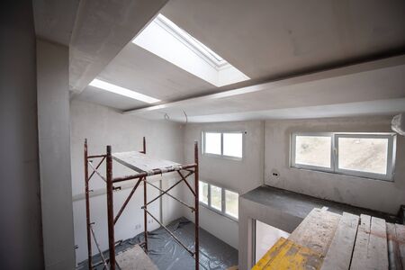 interior of construction site with scaffolding in a large modern unfinished duplex apartmentの写真素材