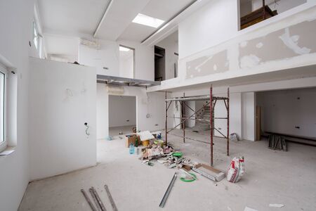 interior of construction site with scaffolding in a large modern unfinished duplex apartmentの写真素材