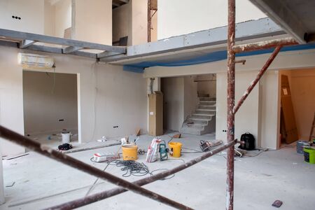 interior of construction site with scaffolding in a large modern unfinished duplex apartmentの写真素材