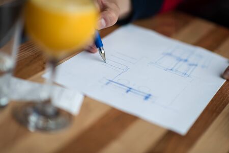 The hand of the designer with a pen, designing and sketching his idea for a furniture productの写真素材