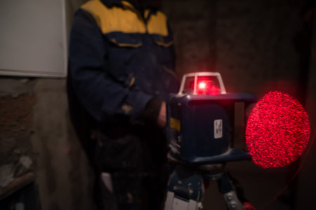 professional worker using laser level in a building under construction. Laser equipment at a...