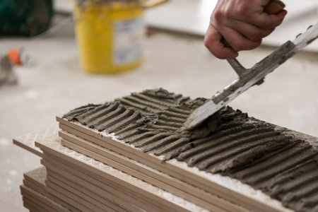 skilled worker installing the ceramic wood effect tiles on the floor Worker making laminate flooring on the construction site of the new apartmentの写真素材