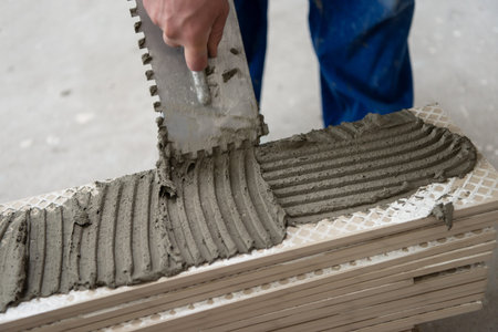 skilled worker installing the ceramic wood effect tiles on the floor Worker making laminate flooring...