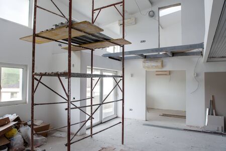 interior of construction site with scaffolding in a large modern unfinished duplex apartmentの写真素材