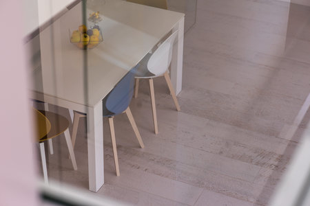 outside view trough window dining table in luxury interior of stylish modern open space two level...