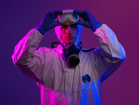 Doctor wearing protective biological suit and mask due to coronavirus 2019-nCoV global pandemic...