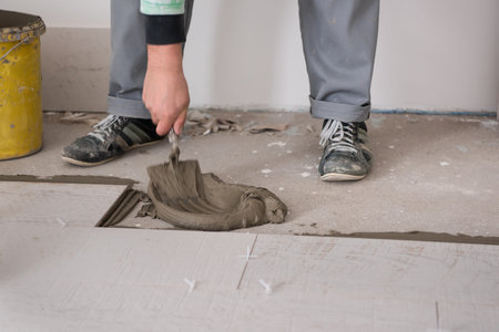 skilled worker installing the ceramic wood effect tiles on the floor Worker making laminate flooring on the construction site of the new apartmentの写真素材