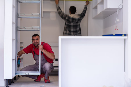 two professional workers installing a new stylish modern kitchen furniture