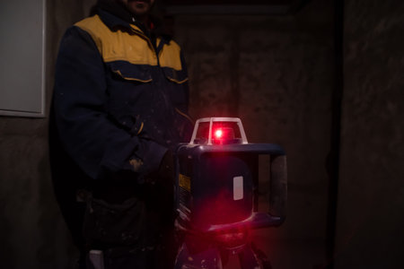 professional worker using laser level in a building under construction. Laser equipment at a...