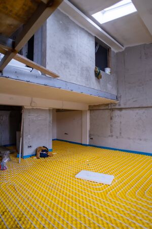 yellow underfloor heating installation with white polyethylene pipes on construction site of new two level apartmentの写真素材