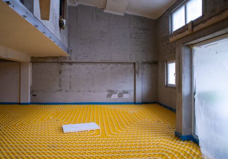 yellow underfloor heating installation with white polyethylene pipes on construction site of new two level apartmentの写真素材