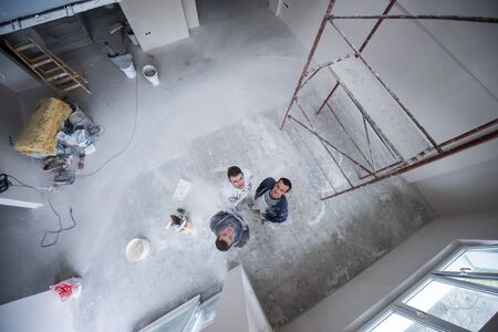 top view portrait of Workers and builders with dirty uniform in apartment that is under construction, remodeling,renovation,extension, restoration, overhaul and reconstructionの写真素材