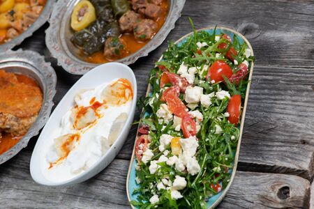 Eid Mubarak Traditional Ramadan Iftar dinner. Assorted tasty food in authentic rustic dishes on wooden blue background.  Turkish Bosnian food meat kebab, pita, Sarma, klepe, sogan dolma,  fried meatballs. Middle eastern dates.  Turkish cuisine. Top view. Eastern foodの写真素材