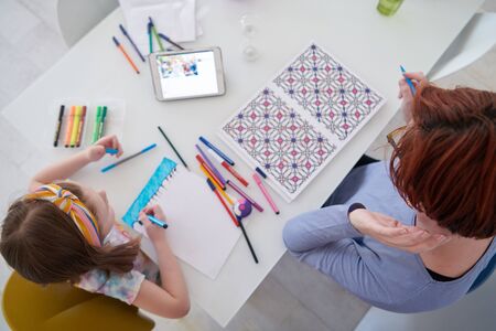 Mother and little daughter  playing together  drawing creative artwork during coronavirus quarantineの写真素材